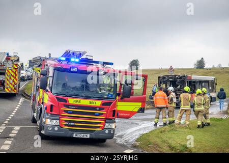 Der Ort nach einem Busbrand wurde von den Feuerwehrleuten auf Minchinhampton Common, Gloucestershire, Großbritannien (Januar 2025) gelöscht. Stockfoto