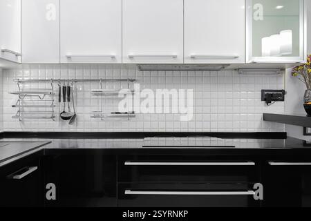 Fassade weiße und schwarze Küchenmöbel im Kücheninnenraum Stockfoto