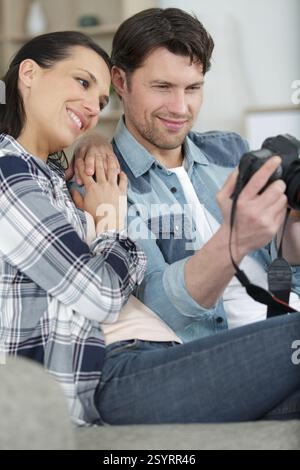 Ein lächelndes Paar überprüft Fotos im Bus Stockfoto