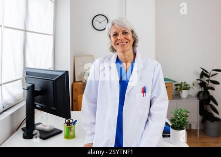 Porträt einer reiferen Ärztin mit Blick auf die Kamera in ihrer Praxis Stockfoto