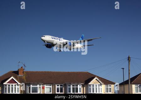 Die United Airlines Boeing 777-222 er N791UA fliegt tief über der Myrtle Avenue, Hounslow, bevor sie am Flughafen Heathrow landet. Stockfoto