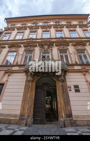 Flaches Bild eines großen, reich verzierten Gebäudes mit dekorativer Fassade, markantem Balkon, komplizierten Schnitzereien und einer großen, offenen Holztür Stockfoto