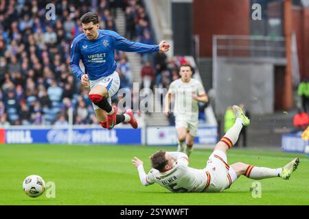 Glasgow, Großbritannien. März 2025. Rangers FC spielte Motherwell FC im Ibrox Stadium in Glasgow, Schottland, Großbritannien in einem Spiel der schottischen Premiership. Das Finale war die Rangers 1:2 Motherwell. Ianis Hagi (R30) weicht einem Rutschgerät von Kofi Balmer (M5) aus. Quelle: Findlay/Alamy Live News Stockfoto