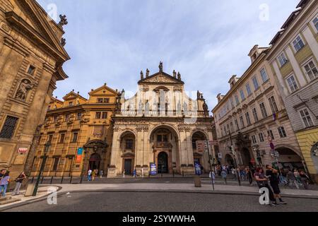 Eine barocke Kirche mit einer symmetrischen Fassade mit Statuen, Bogenöffnungen und einer markanten grünen Kuppel befindet sich auf einem Stadtplatz Stockfoto