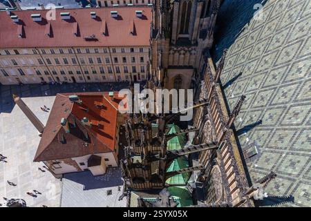 Ein beeindruckender Luftschuss direkt über einer historischen Kathedrale, der seine komplizierte Dachterrasse, Türme und angrenzende Gebäude mit rot gekachelten Dächern und zeigt Stockfoto