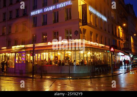 PARIS, Frankreich - 23. Februar 2025 : Restaurant La Creme de Paris bei regnerischer Nacht. Es liegt in der Nähe der U-Bahn-Station St. Michel, spezialisiert auf süße A Stockfoto