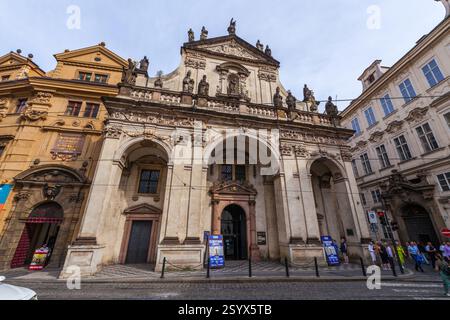Eine barocke Kirche mit symmetrischer Fassade mit Statuen, bogenförmigen Öffnungen und dekorativen Details steht an prominenter Stelle auf einem Stadtplatz Stockfoto