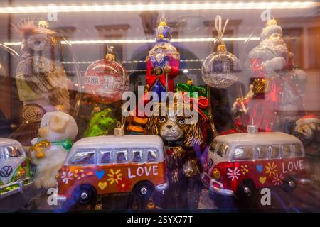 Eine lebendige Sammlung von Vintage-Weihnachtsschmuck, darunter Tierfiguren, Fahrzeuge und ein Nussknacker, wird in einem Glaskoffer ausgestellt, in dem f Stockfoto