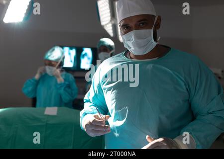 Porträt eines birassischen männlichen Chirurgen im Operationssaal im Krankenhaus Stockfoto