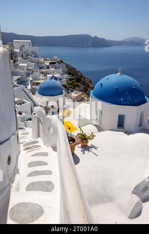 Oia, Santorini, Griechenland - 3. Juli 2021: Blick vom Aussichtspunkt auf das Dorf Oia mit blauer Kuppel der griechisch-orthodoxen christlichen Kirche. Santorin, Griechenland Stockfoto