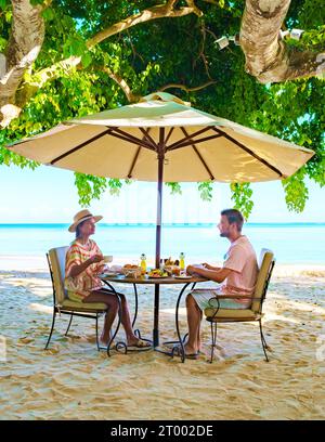 Mann und Frau beim Frühstück an einem tropischen Strand auf Mauritius Stockfoto