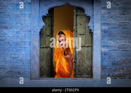 Rajasthani, junge Frau, die durch das Fenster guckt Stockfoto