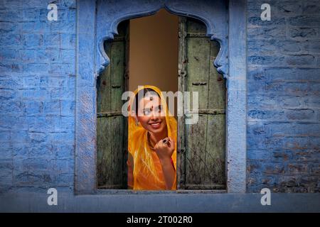 Rajasthani, junge Frau, die durch das Fenster guckt Stockfoto