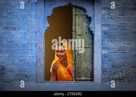 Rajasthani, junge Frau, die durch das Fenster guckt Stockfoto