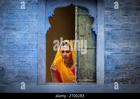 Rajasthani, junge Frau, die durch das Fenster guckt Stockfoto