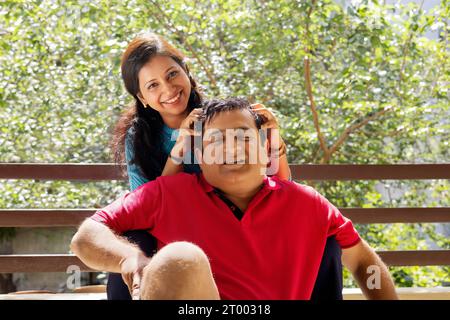 Frau, die ihrem Mann auf dem Balkon eine Kopfbotschaft übergibt Stockfoto