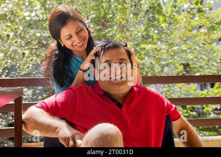 Frau, die ihrem Mann auf dem Balkon eine Kopfbotschaft übergibt Stockfoto