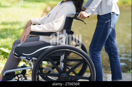 Pflegeheim. Junge Pflegekraft hilft Seniorin im Rollstuhl. Stockfoto