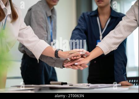 Nahaufnahme von Geschäftsleuten, die ihre Hände zusammenlegen. Geschäftskollegen zeigen Einheit am Arbeitsplatz. Stockfoto