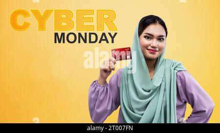 Muslimische Frau im Kopftuch mit Kreditkarte. Cyber Monday-Konzept Stockfoto