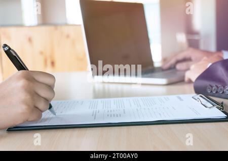 Mann, der das Bewerbungsformular während des Vorstellungsgesprächs ausfüllt. Personalkonzept. Stockfoto