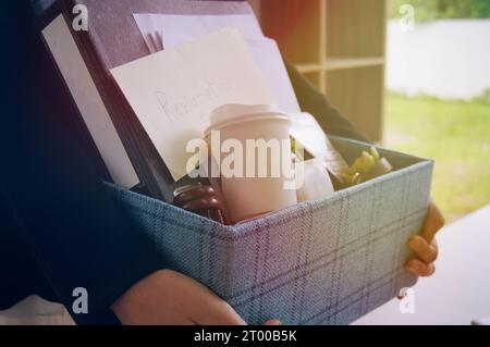 Geschäftsfrau, die das Büro verlegt und Pappkarton im Büro verstaut. Stockfoto