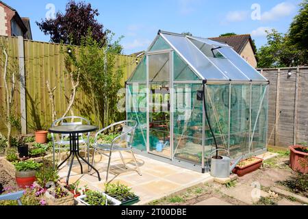 Neues modernes Polycarbonat-Hybridgewächshaus mit Tisch und Stühlen im Vordergrund, Chard, Somerset, Großbritannien, Europa Stockfoto