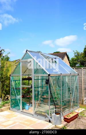 Neues modernes Polycarbonat-Hybridgewächshaus mit Tisch und Stühlen im Vordergrund, Chard, Somerset, Großbritannien, Europa Stockfoto