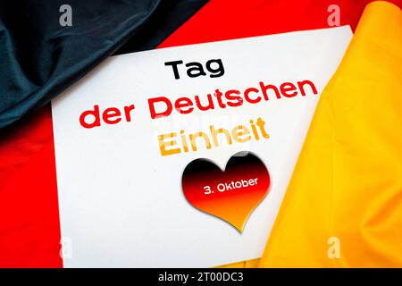 Tag der deutschen Einheit mit Herz in Deutschland. Oktober 2023. Farben mit Inschrift 3. Oktober auf einer Deutschland-Flagge FOTOMONTAGE *** Tag der Deutschen Einheit mit einem Herz in Deutschland Farben mit Aufschrift 3. Oktober auf einer Deutschland Flagge FOTOMONTAGE Credit: Imago/Alamy Live News Stockfoto