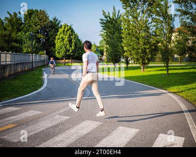 Ein Mann überquert die Straße in der Mitte der Straße und schwebt auf magische Weise in der Luft Stockfoto