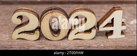 Natur Holzbriefe in der Sonne an einem sonnigen glücklichen Tag. Worttext aus Holzbuchstaben erstellen. Natürlich Holz Hintergrund, Buchstaben Zahlen 2024 Stockfoto