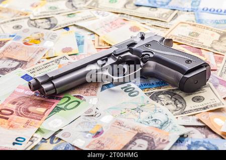 Handfeuerwaffe auf den verschiedenen Banknoten Hintergrund. Stockfoto