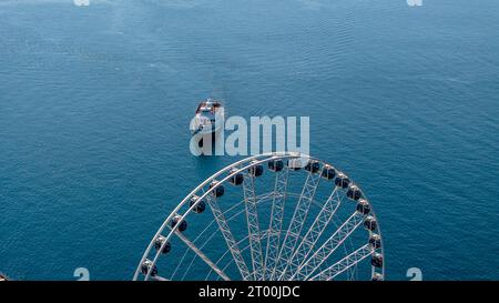 Luftaufnahme Eines Fährschiffes mit Einem Riesenrad im Vordergrund Stockfoto