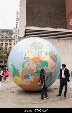 Mark Wallinger's The World stellte einen riesigen Globus auf den Kopf vor dem SAW Swee Hock Student Centre, London School of Economics, London, WC2, England Stockfoto