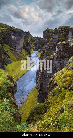 Der Fluss Fjadra fließt durch den wunderschönen Canyon Fjadrargljufur. Südisland. Bewölkter Herbsttag. Es befindet sich in der Nähe des Ringes Stockfoto