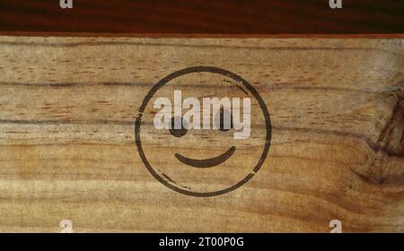 Smiley Emoticon Symbol Stempel gedruckt auf Holzkiste. Smile Emoji-Konzept. Stockfoto