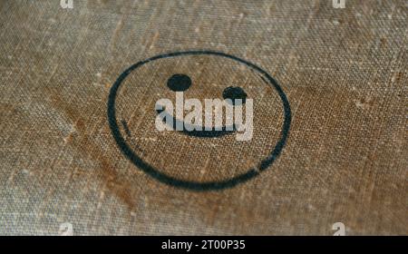 Smiley Emoticon Symbol Stempel gedruckt auf Leinensack. Smile Emoji-Konzept. Stockfoto