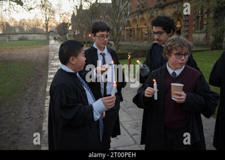 Privatschüler Großbritannien. Privatausbildung überseeische Studenten 2020er Jahre Winchester College jährliche Illumina-Zeremonie. „College Junior Men“ Dies sind junge Schüler, die Schüler sind, die Kerzen in Nischen in der mittelalterlichen Meads-Mauer anzünden. (Die Wand, die ein Spielfeld umgibt.) Winchester, Hampshire, England, 9. Dezember 2022. HOMER SYKES AUS DEN 2020ER JAHREN. Stockfoto