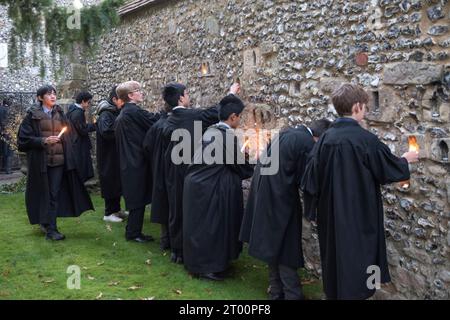 Winchester School Hampshire. Studenten bei der jährlichen Illumina-Zeremonie. „College Junior Men“ Dies sind Studenten, die Gelehrte sind, Lichtkerzen in Nischen in der mittelalterlichen Meads Mauer platziert werden. (Die Wand, die ein Spielfeld umgibt.) Winchester, Hampshire, England, 9. Dezember 2022. HOMER SYKES. Stockfoto