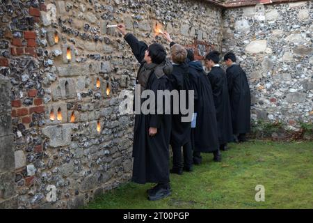 Winchester College Hampshire. Schüler der jährlichen Illumina-Zeremonie. Private Bildung 2020s UK. „College Junior Men“ Dies sind Studenten, die Gelehrte sind, Lichtkerzen in Nischen in der mittelalterlichen Meads Mauer platziert werden. (Die Wand, die ein Spielfeld umgibt.) Winchester, Hampshire, England, 9. Dezember 2022. HOMER SYKES. Stockfoto