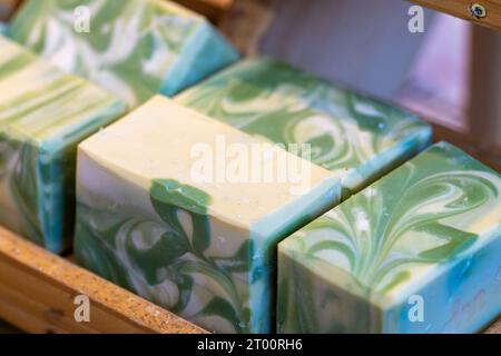 Handgemachte Seife mit grüner Farbe in Blöcken nebeneinander auf einem Regal zum Verkauf Stockfoto