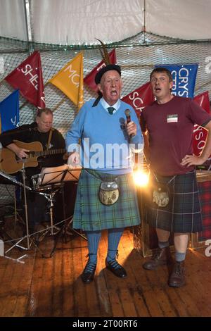 Schottland Kilt. Cockenzie und Port Seton freundliche Gesellschaft der Fischer. Das Box Meeting Ceilidh. Der ehemalige Fischer und Skipper Archie Johnston (86 Jahre) und Gareth Jones sangen Aberlady Bay: „Der Blaue liegt vor uns, Jungs, der Wind weht fair und frei, das Boot gleitet über die Kammwelle, als würde sie hame ... sein September 2023 Cockenzie und Port Seton, East Lothian, Schottland. HOMER SYKES AUS DEN 2020ER JAHREN Stockfoto