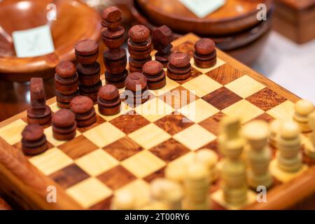 Holzschach mit braunen und weißen Stücken, fotografiert von schräg oben Stockfoto