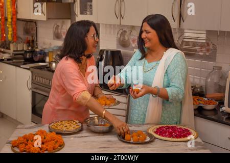 Schwiegermutter und Schwiegertochter machen Ladoo anlässlich von Diwali Stockfoto