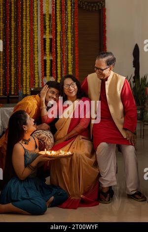 Porträt einer glücklichen indischen Familie in traditionellem Outfit zu Hause auf Diwali Stockfoto