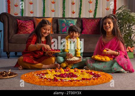 Kinder, die zusammen Rangoli aus Anlass von Diwali herstellen Stockfoto