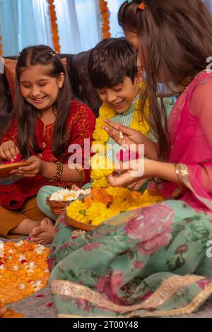 Kinder, die zusammen Rangoli aus Anlass von Diwali herstellen Stockfoto