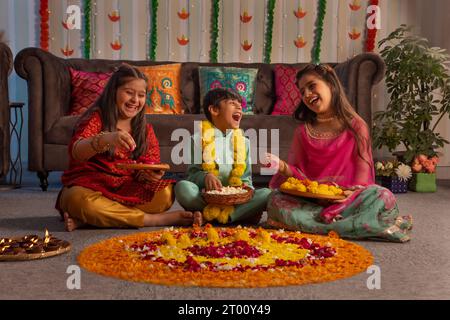 Kinder, die zusammen Rangoli aus Anlass von Diwali herstellen Stockfoto