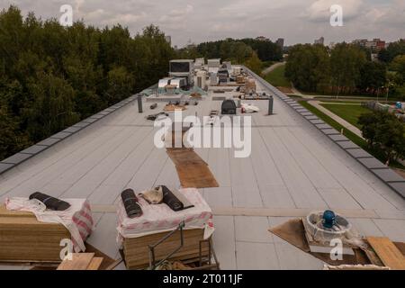 Drohnenfotografie des neuen Gebäudes auf der Dachterrasse, die mit Baumaschinen während des bewölkten Sommers gebaut wird Stockfoto