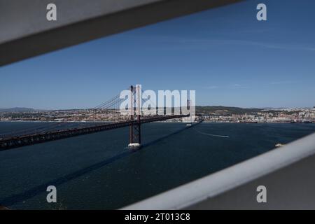 Lissabon, Portugal. August 2023. Allgemeine Ansicht der Brücke vom 25. April aus einem der Aussichtspunkte in der Nähe des Denkmals Christi des Königs in Almada, Lissabon. Das Nationalheiligtum Christi des Königs ist ein religiöses Denkmal in der Stadt Almada, im Ballungsgebiet von Lissabon, Portugal. Es handelt sich um einen Säulengang, der von der Statue Jesu Christi gekrönt wird, mit offenen Armen zur Stadt Lissabon hin und ist mit einer Höhe von 110 Metern eines der höchsten Gebäude Portugals. Quelle: SOPA Images Limited/Alamy Live News Stockfoto